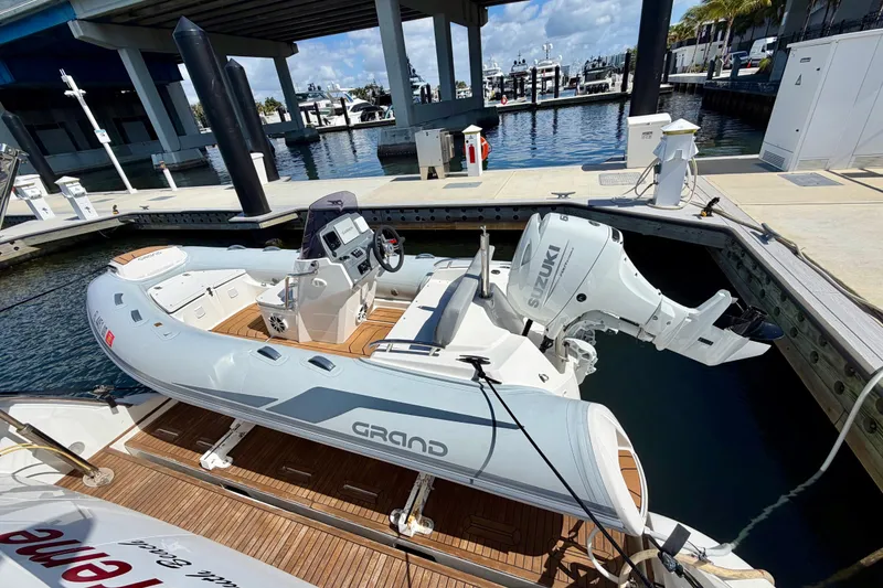 Slide: The Image of Inflatable boat with Suzuki outboard motor docked at marina, near Azimut 60 yacht. - 62