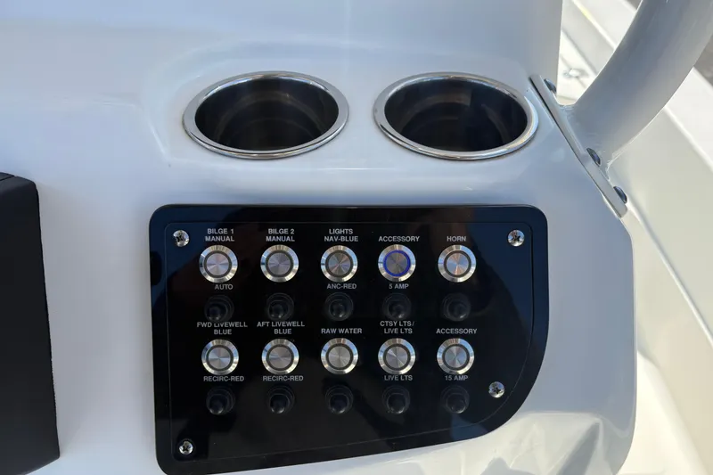 Slide: The Image of Control panel of 2021 NauticStar 227 XTS boat with cup holders and switches. - 18