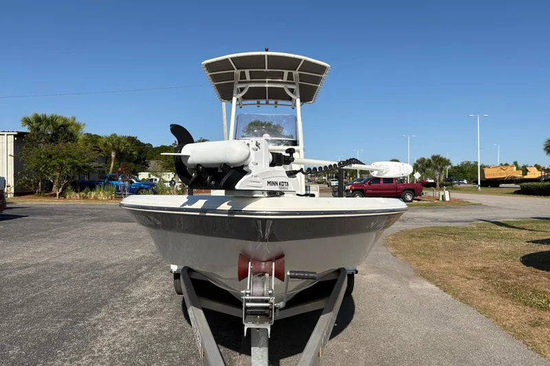 Slide: The Image of 2021 NauticStar 227 XTS boat on trailer, parked outdoors under clear blue sky. - 5