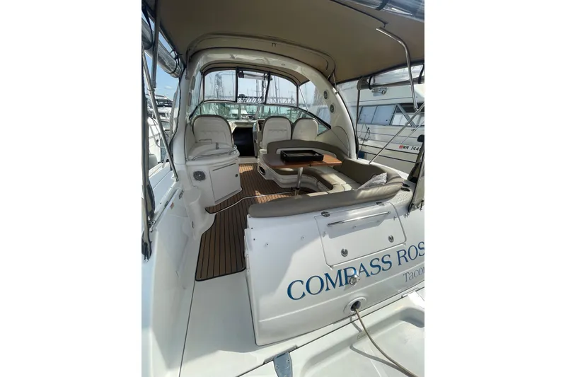 Slide: The Image of 2003 Sea Ray 340 Sundancer interior with seating and table, docked at marina. - 10