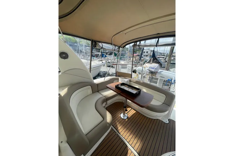 Slide: The Image of Interior of 2003 Sea Ray 340 Sundancer yacht with seating and table, docked at marina. - 12