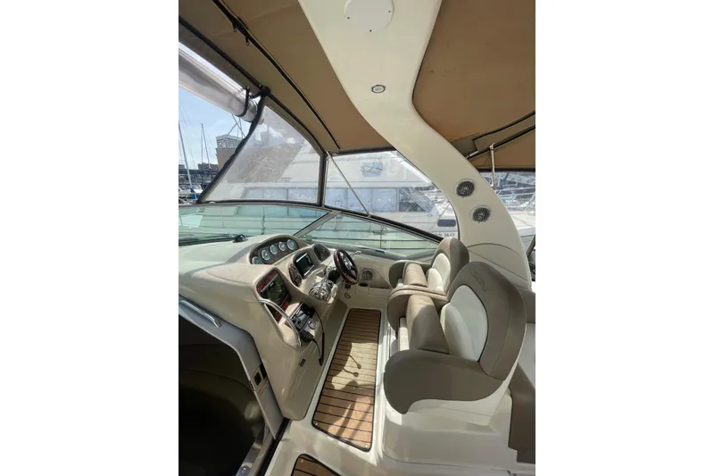 Slide: The Image of 2003 Sea Ray 340 Sundancer cockpit with helm, steering wheel, and seating. - 16