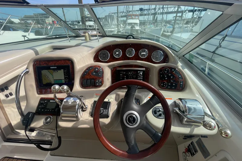 Slide: The Image of Cockpit view of a 2003 Sea Ray 340 Sundancer with navigation instruments and steering wheel. - 18
