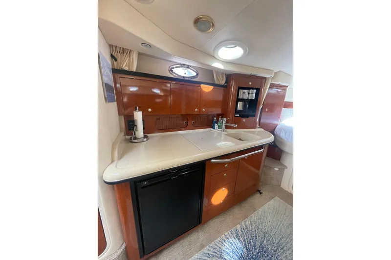 Slide: The Image of 2003 Sea Ray 340 Sundancer yacht interior kitchen with wood cabinetry and modern appliances. - 32