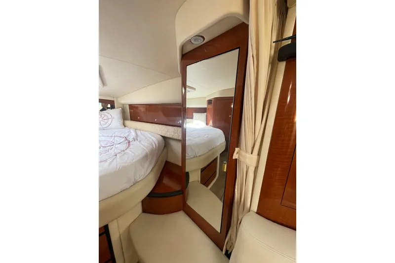 Slide: The Image of Interior of 2003 Sea Ray 340 Sundancer yacht, featuring a cozy bed and elegant wood finishes. - 38