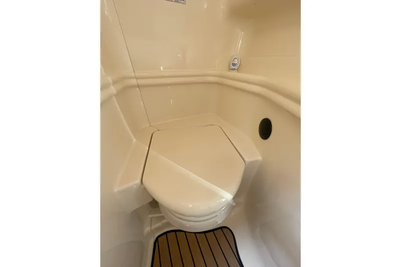 Slide: The Image of 2003 Sea Ray 340 Sundancer boat bathroom with compact toilet and beige interior. - 43