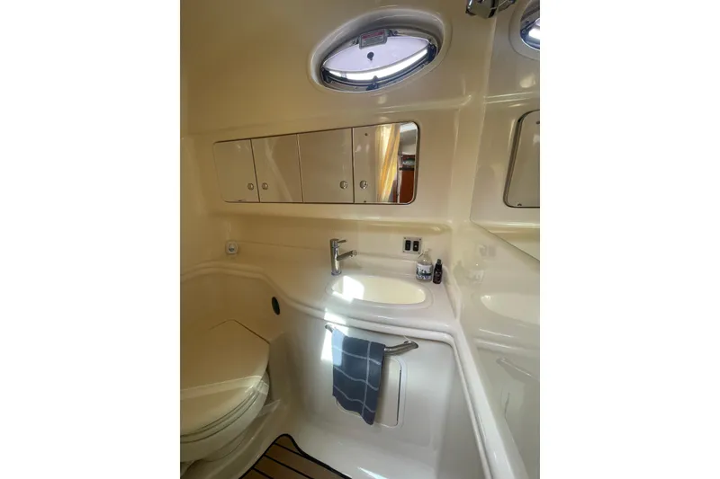 Slide: The Image of 2003 Sea Ray 340 Sundancer bathroom with sink, mirror, and storage cabinets. - 44