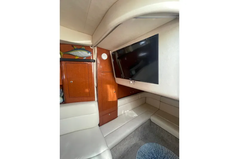 Slide: The Image of Interior of 2003 Sea Ray 340 Sundancer with TV, seating, and wooden cabinetry. - 45