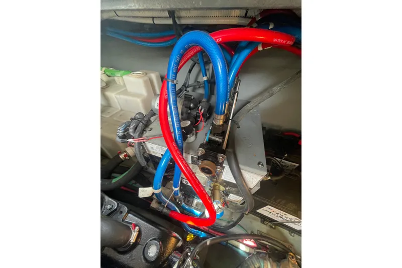 Slide: The Image of Engine compartment of a 2003 Sea Ray 340 Sundancer with red and blue hoses. - 51