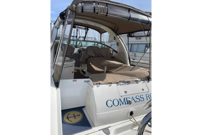 Slide: The Image of 2003 Sea Ray 340 Sundancer boat interior with covered seating and nautical decor. - 57