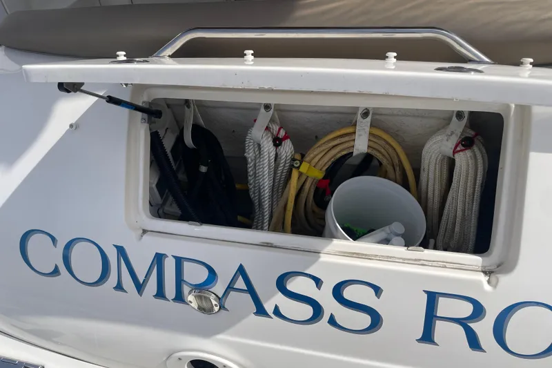 Slide: The Image of Storage compartment on a 2003 Sea Ray 340 Sundancer boat with ropes and cleaning supplies. - 58