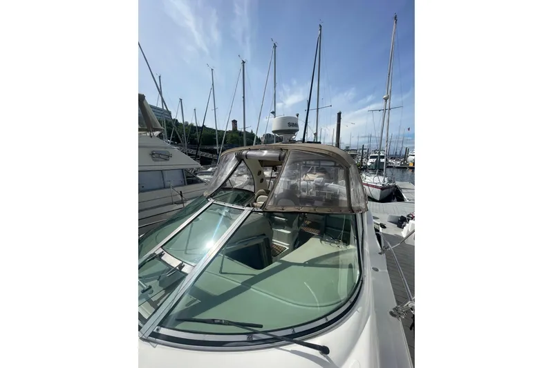 Slide: The Image of 2003 Sea Ray 340 Sundancer docked at marina, clear canopy, blue sky background. - 9