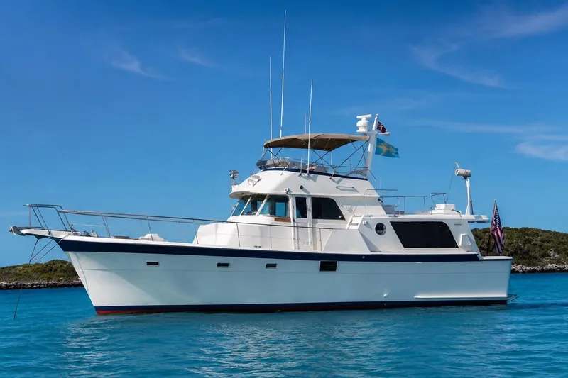 The Image of 1976 Hatteras 48 Long Range Cruiser yacht on clear blue water under a sunny sky. - 1