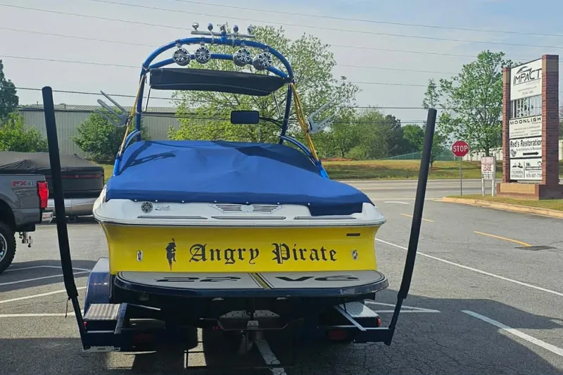 Slide: The Image of 2006 Tigé 22Ve boat named "Angry Pirate" with blue cover in parking lot. - 10