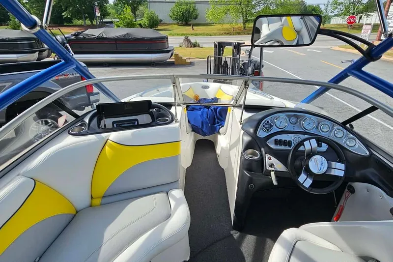 Slide: The Image of Interior of a 2006 Tigé 22Ve boat with yellow and gray seating, dashboard, and steering wheel. - 15