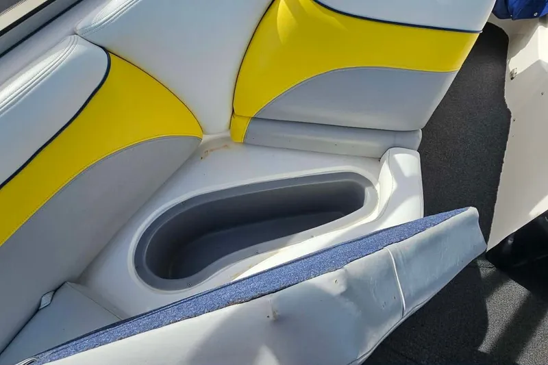 Slide: The Image of 2006 Tigé 22Ve boat interior with yellow and gray seating and storage compartment. - 17