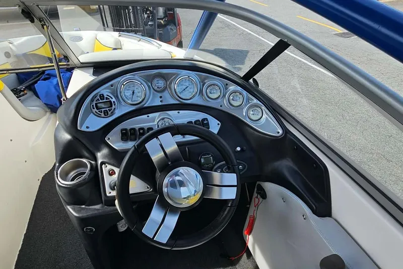 Slide: The Image of 2006 Tigé 22Ve boat dashboard with steering wheel and gauges, showcasing sleek design. - 18