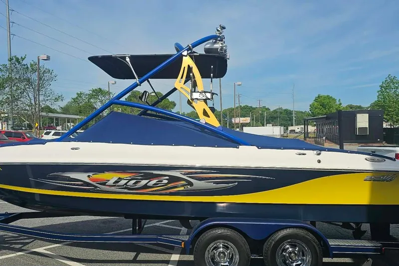 Slide: The Image of 2006 Tigé 22Ve boat with vibrant yellow and blue design on a trailer. - 5
