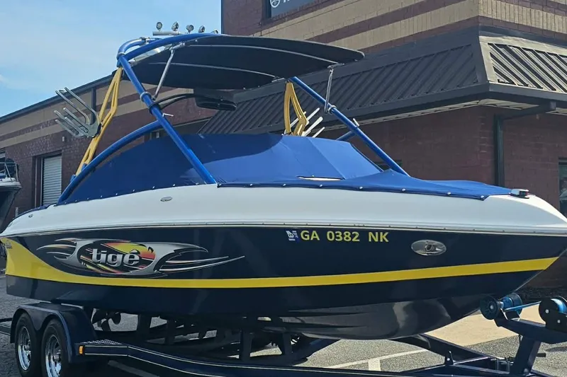 Slide: The Image of 2006 Tigé 22Ve boat with blue and yellow accents on a trailer. - 6