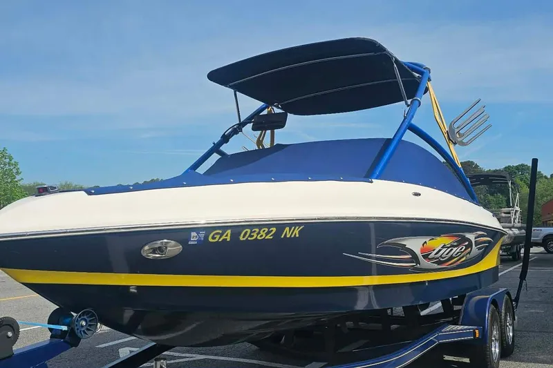 Slide: The Image of 2006 Tigé 22Ve boat with blue and yellow accents on a trailer. - 7