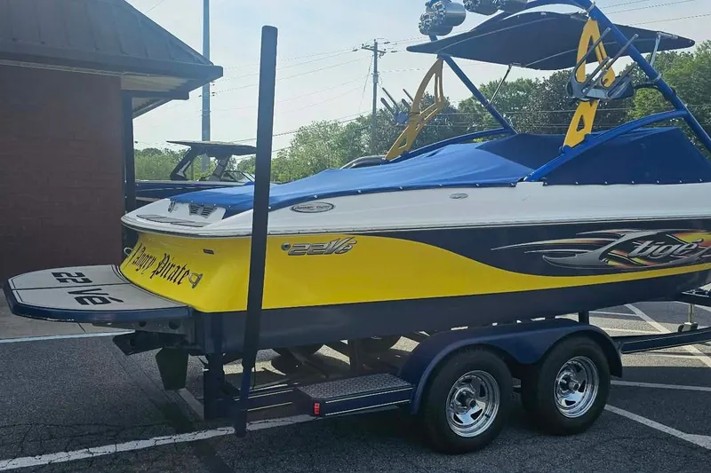 Slide: The Image of 2006 Tigé 22Ve boat on trailer, featuring vibrant yellow and blue design. - 8