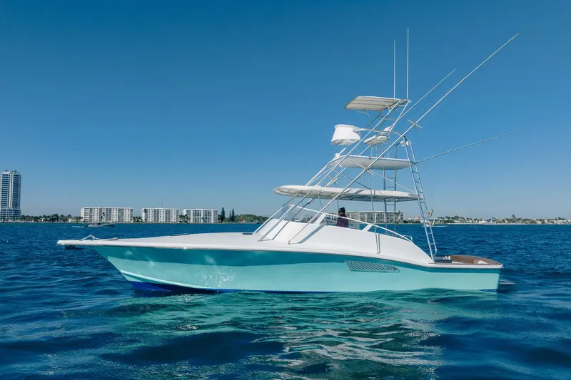 The Image of 1997 Strike 42 Express boat on clear blue water with city skyline background. - 1