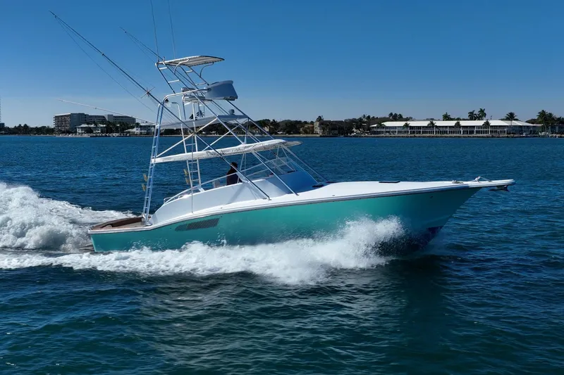 Slide: The Image of 1997 Strike 42 Express boat cruising on clear blue water. - 12