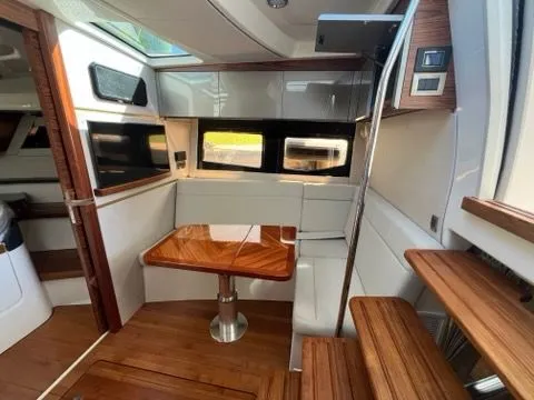 Slide: The Image of Interior of 2023 Boston Whaler 405 Conquest with wooden table and seating area. - 3