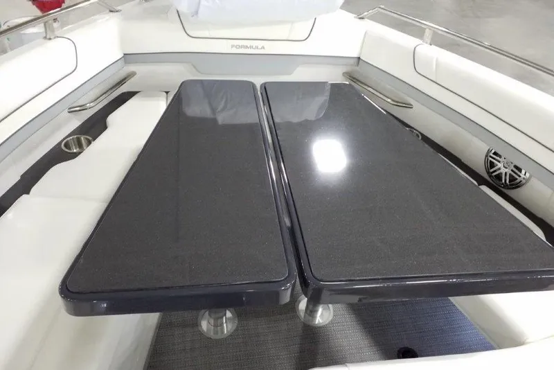 Slide: The Image of 2021 Formula 330 Crossover Bowrider interior with sleek black table and white seating. - 17