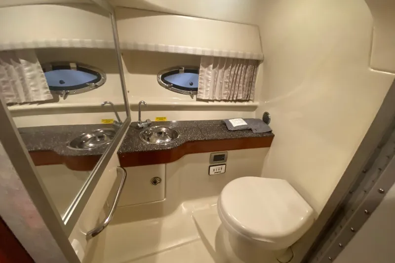 Slide: The Image of 2007 Formula 310 Sun Sport boat bathroom with sink, mirror, and porthole windows. - 32