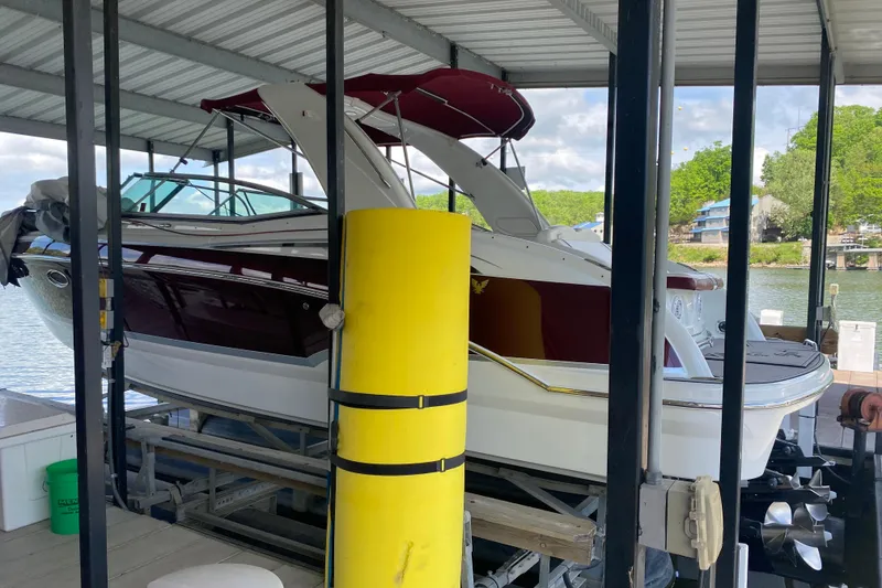 Slide: The Image of 2007 Formula 310 Sun Sport boat docked under a covered marina with scenic lake view. - 9