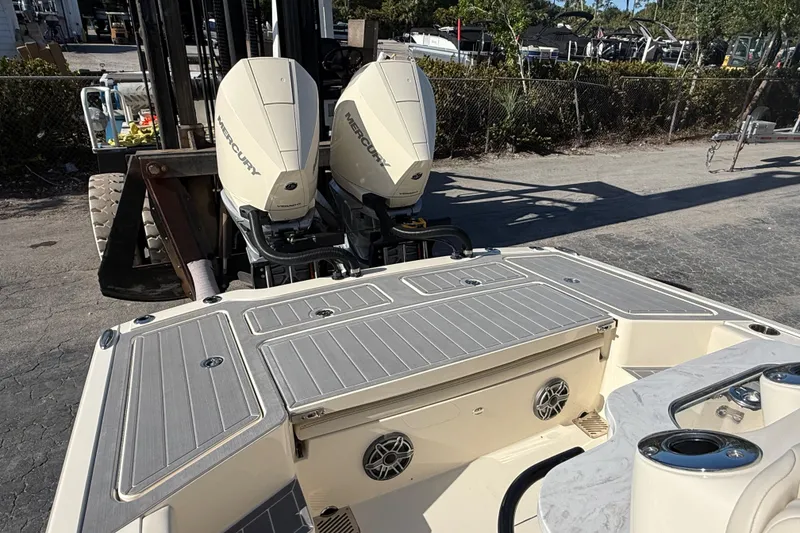 Slide: The Image of 2026 Scout 281 XSS boat with dual Mercury outboard engines, docked outdoors. - 11