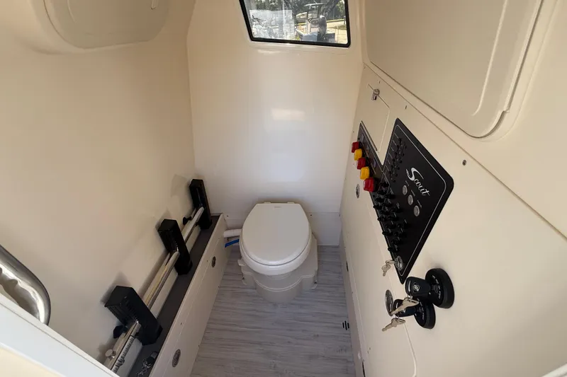 Slide: The Image of Interior of 2026 Scout 281 XSS boat bathroom with control panel and toilet. - 19
