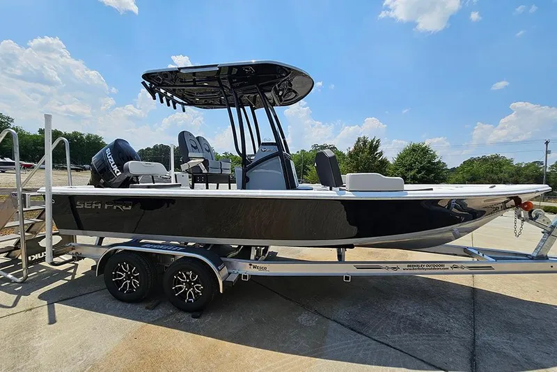 Slide: The Image of 2026 Sea Pro 230 Bay boat on trailer under clear blue sky. - 6