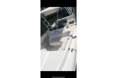 Slide: The Image of 2001 Intrepid 322 Cuddy boat with seating and canopy, docked in sunlight. - 12
