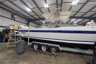 Slide: The Image of 2001 Intrepid 322 Cuddy boat in a warehouse on a trailer. - 15