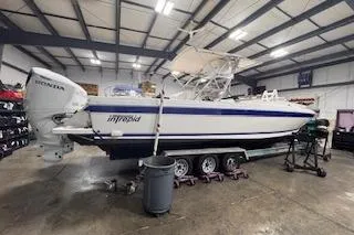 Slide: The Image of 2001 Intrepid 322 Cuddy boat in a garage, on a trailer, with Honda outboard engines. - 16