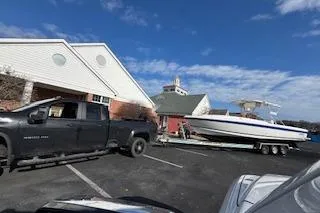 Slide: The Image of Truck towing 2001 Intrepid 322 Cuddy boat on trailer in parking lot. - 8