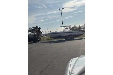 Slide: The Image of 2001 Intrepid 322 Cuddy boat on trailer in parking lot under cloudy sky. - 9