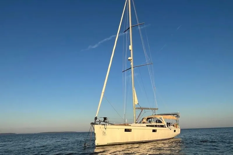 Slide: The Image of 2012 Beneteau Oceanis 48 yacht docked at marina under clear blue sky. - 1