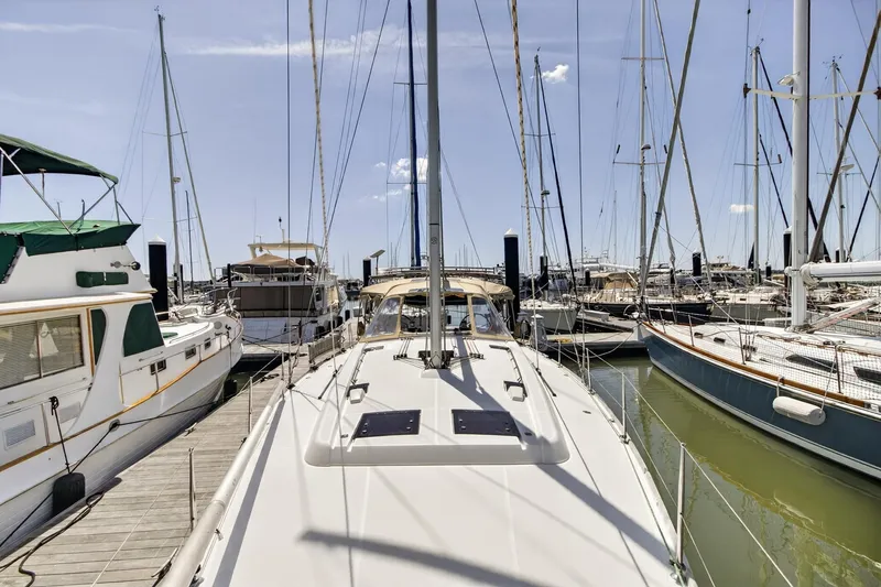 Slide: The Image of Beneteau Oceanis 48 sailboat docked in a marina, surrounded by other boats. - 12