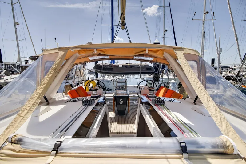 Slide: The Image of 2012 Beneteau Oceanis 48 yacht cockpit with orange cushions and clear canopy in marina. - 16