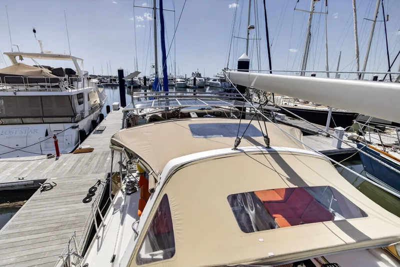 Slide: The Image of Beneteau Oceanis 48 sailboat docked at marina, showcasing deck and canopy, 2012 model. - 17