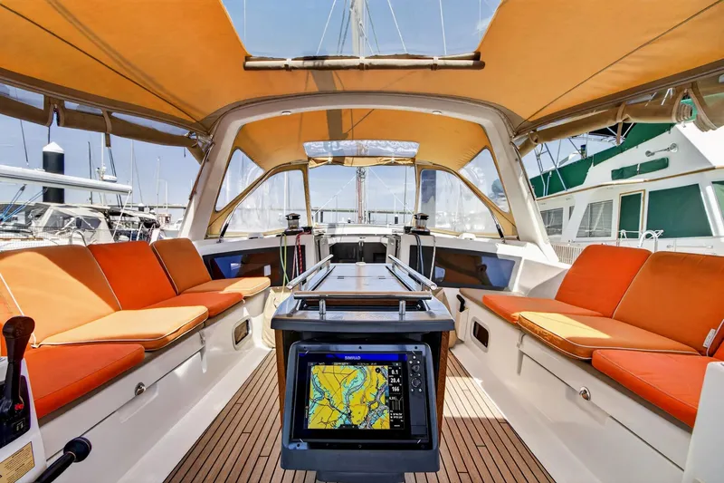 Slide: The Image of Spacious cockpit of 2012 Beneteau Oceanis 48 sailboat with orange seating and navigation display. - 19