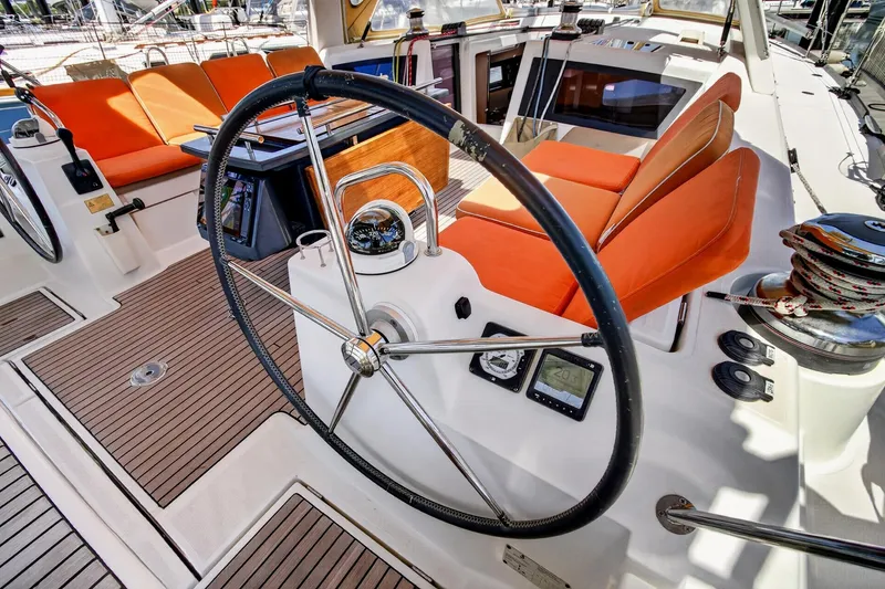 Slide: The Image of Steering wheel and seating area on 2012 Beneteau Oceanis 48 yacht with orange cushions. - 21