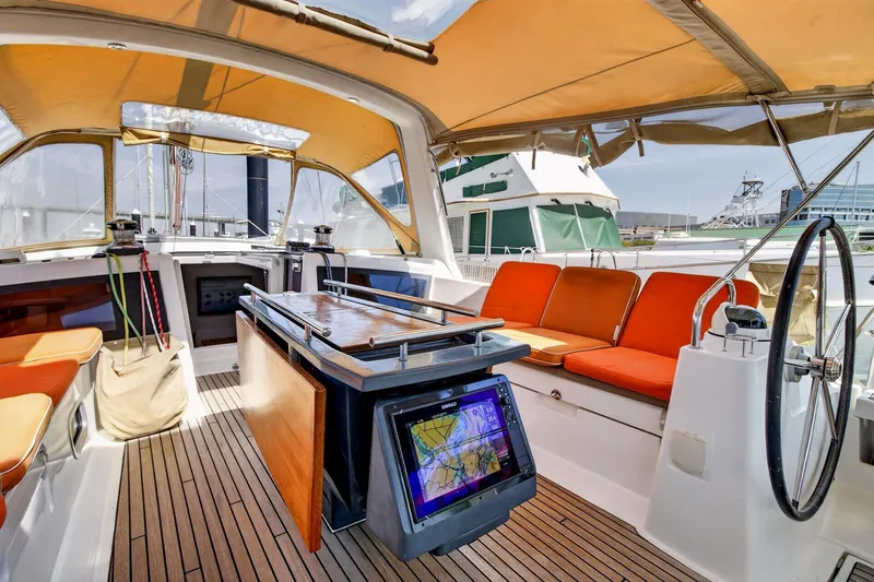 Slide: The Image of Interior view of 2012 Beneteau Oceanis 48 sailboat with orange seating and navigation equipment. - 22