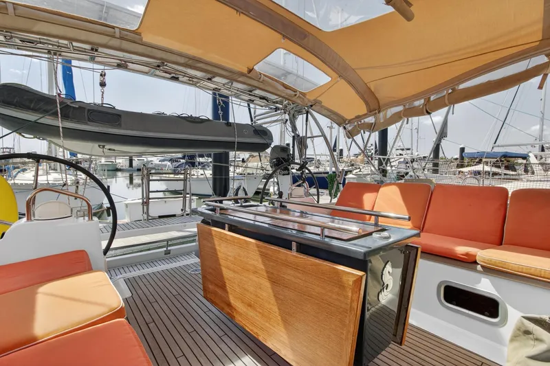 Slide: The Image of 2012 Beneteau Oceanis 48 yacht cockpit with orange seating and wooden table. - 23