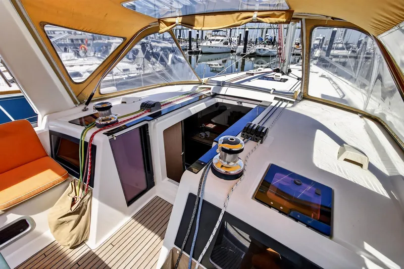 Slide: The Image of 2012 Beneteau Oceanis 48 yacht cockpit with winches, ropes, and seating under canopy. - 24