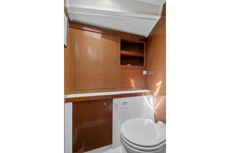 Slide: The Image of Interior of 2012 Beneteau Oceanis 48 yacht bathroom with wooden cabinetry and toilet. - 45