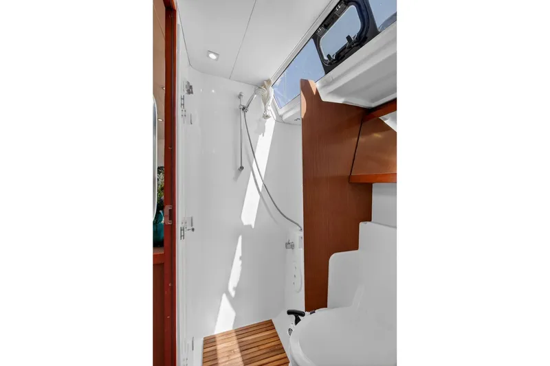 Slide: The Image of Interior of 2012 Beneteau Oceanis 48 yacht bathroom with shower and wooden accents. - 49